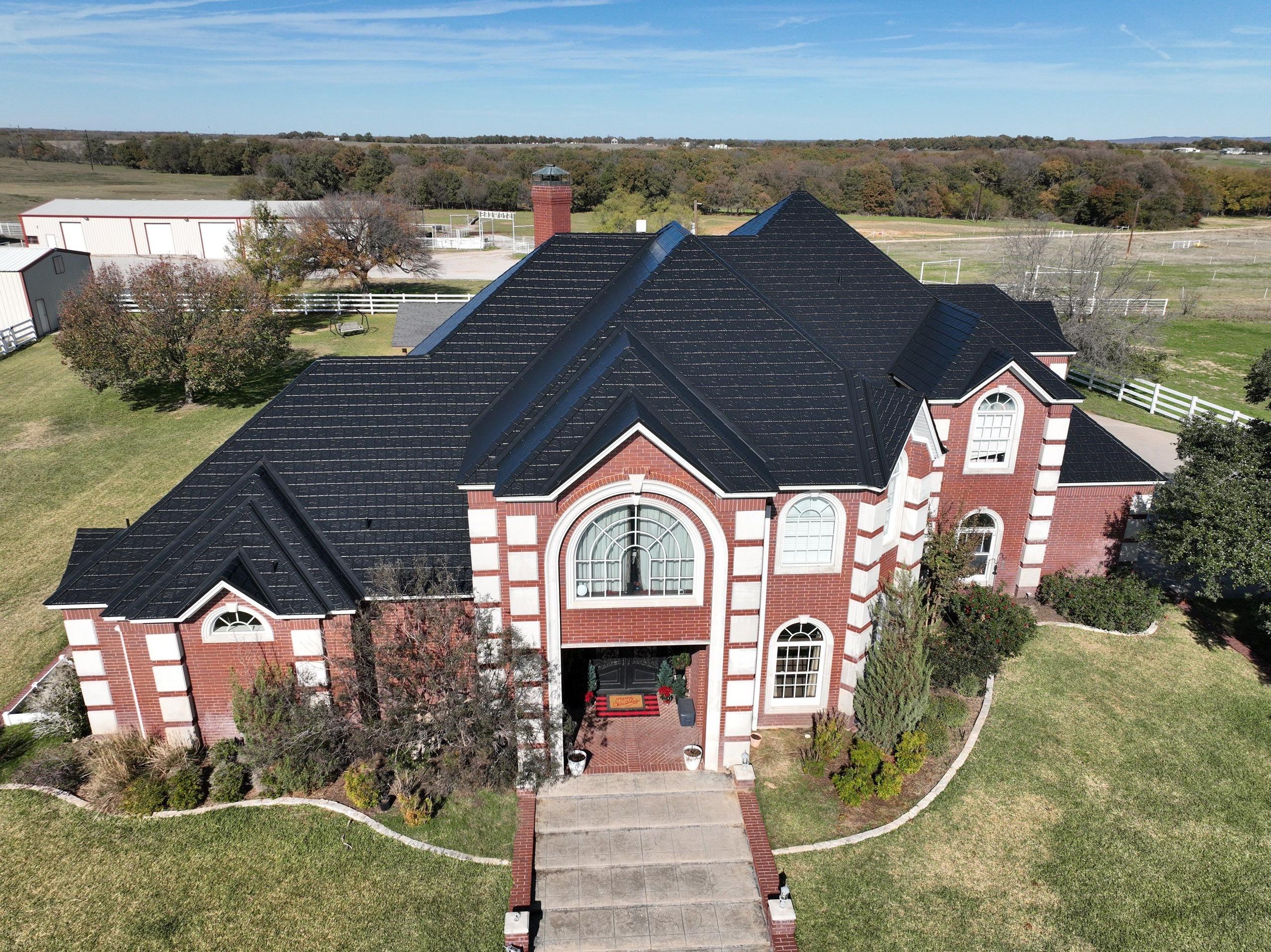 A stately brick home with EDCO’s ArrowLine Black Metal Roofing, providing a sleek, durable contrast to the red brick exterior.