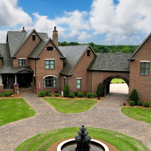 Brick mansion with ArrowLine Slate roofing in T-Tone Blend, adding elegance and durability to its classic design.