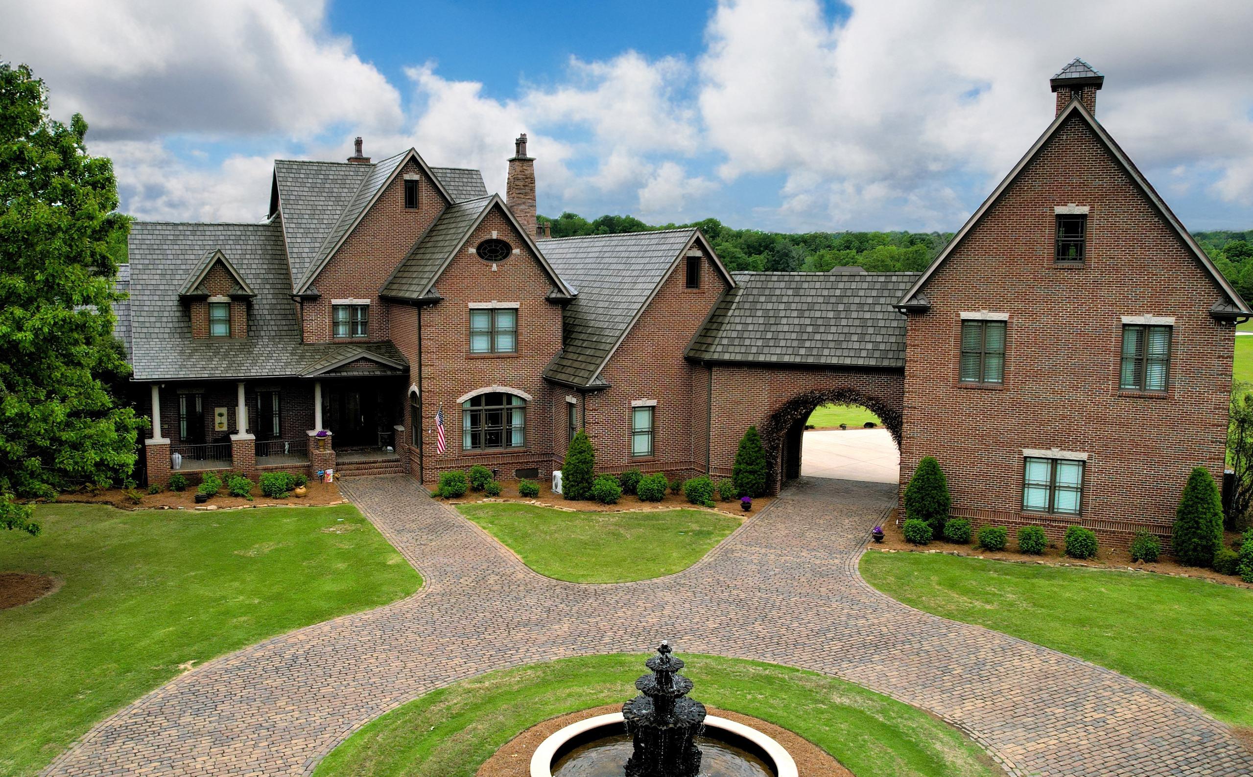 Brick mansion with ArrowLine Slate roofing in T-Tone Blend, adding elegance and durability to its classic design.