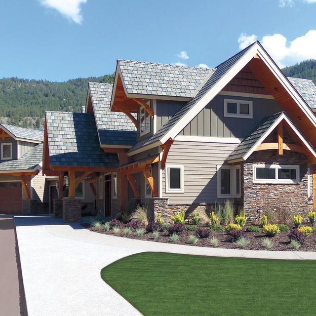 A mountain home showcasing ArrowLine Slate steel roofing in T-Tone Blend, with neutral siding and wood accents for rustic charm.