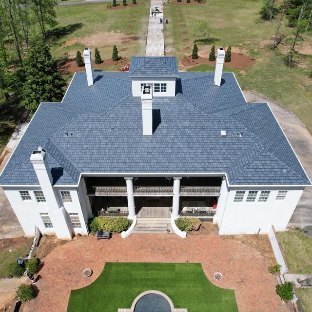Home with ArrowLine Slate steel roofing in Stone Blend, adding timeless appeal to its classic architecture and natural surroundings.