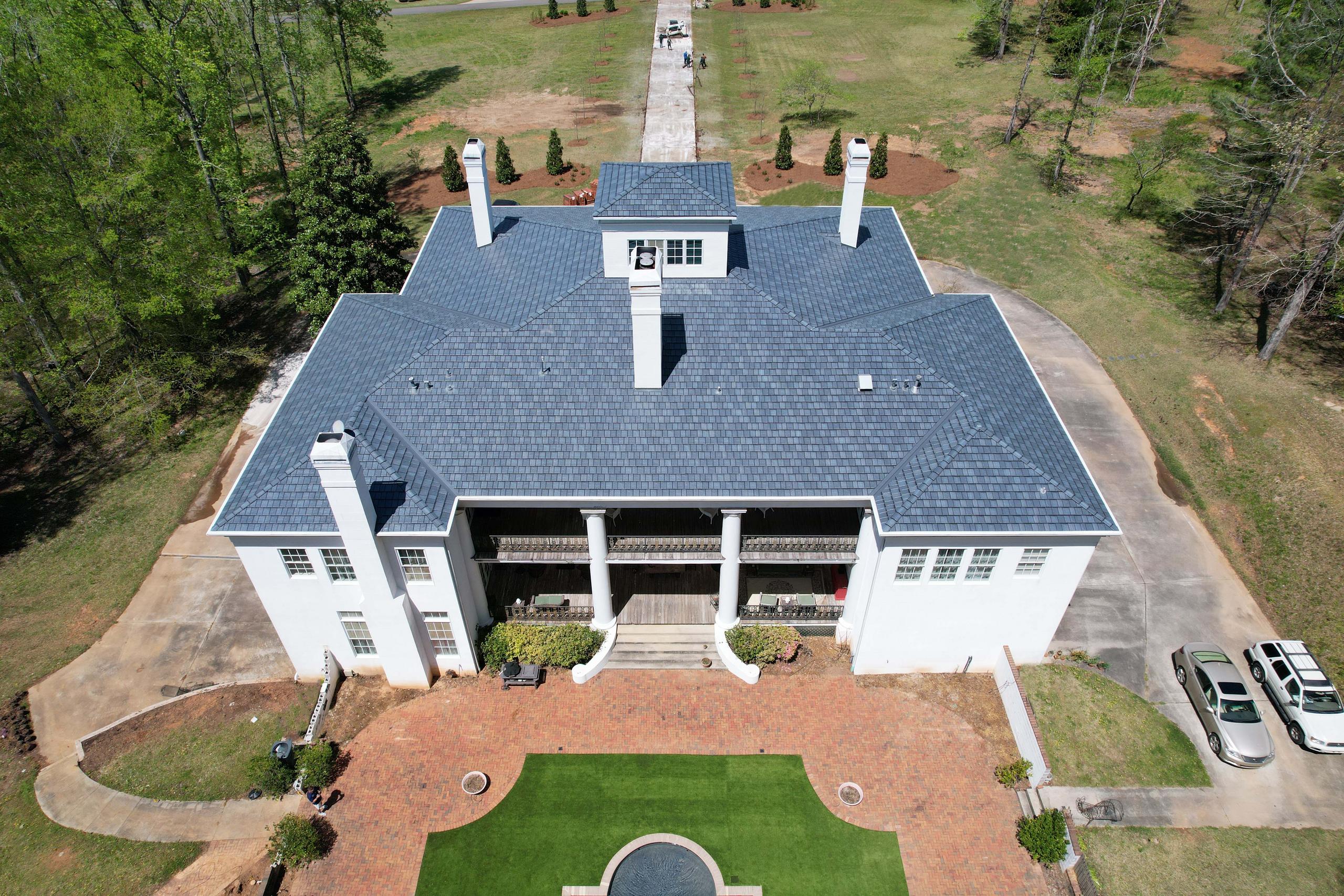 Home with ArrowLine Slate steel roofing in Stone Blend, adding timeless appeal to its classic architecture and natural surroundings.