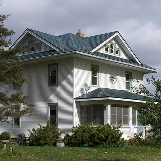 A farmhome local on an acerage outside of the Twin Cities chose Arrowline Shake Hartford Green Blend Roofing to maintain a weathered shake panel look that will last a lifetime