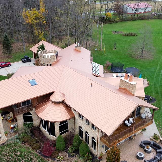 A country estate with a copper metal roof, blending seamlessly with the natural surroundings and offering long-lasting durability.