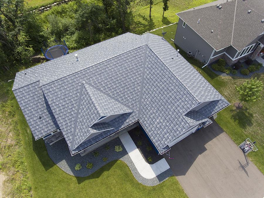 This suburban residence showcases a shake-inspired EDCO metal roof in a classic gray shade. The roofing design complements the home’s architectural features, delivering durability with an upscale aesthetic that enhances curb appeal.