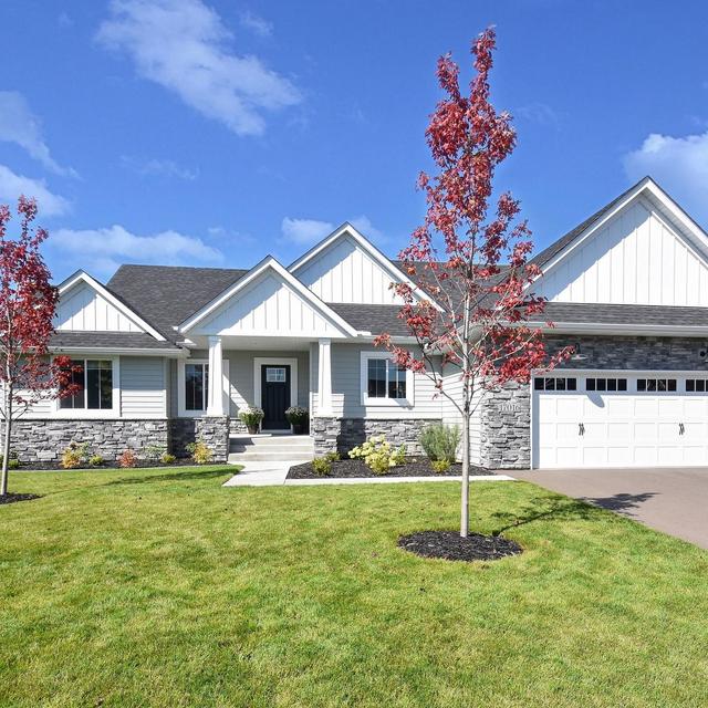 A contemporary home featuring Glacier White steel board and batten siding, Driftwood Gray roofing, and stone accents for a modern, cohesive exterior.