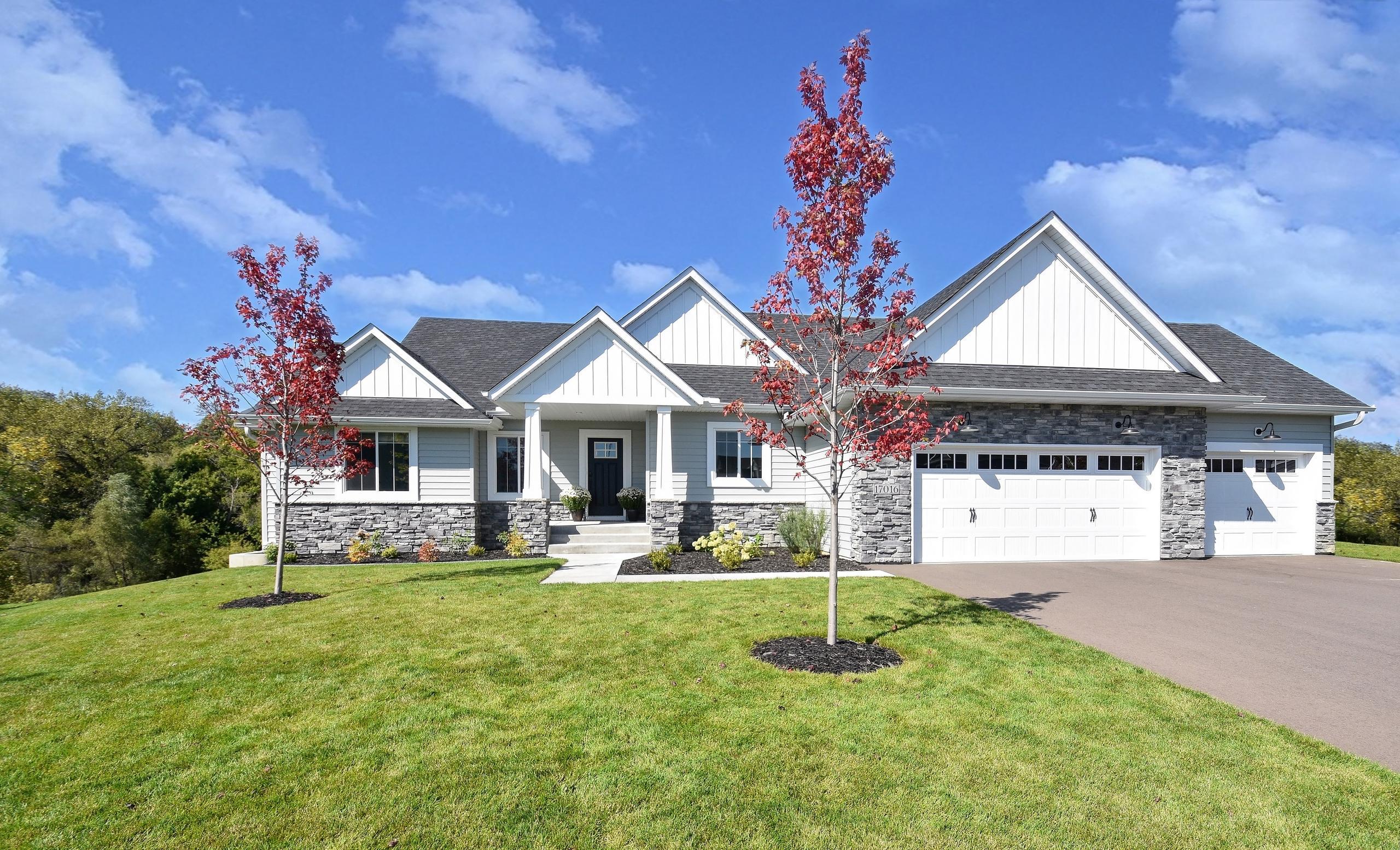 A contemporary home featuring Glacier White steel board and batten siding, Driftwood Gray roofing, and stone accents for a modern, cohesive exterior.