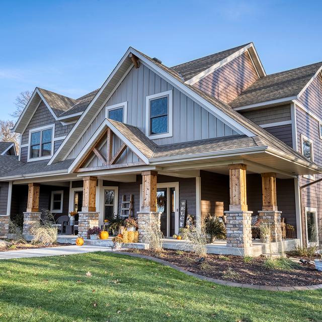 A modern farmhouse with metal board and batten siding in Driftwood Gray and Timber, blending rustic charm with refined design.