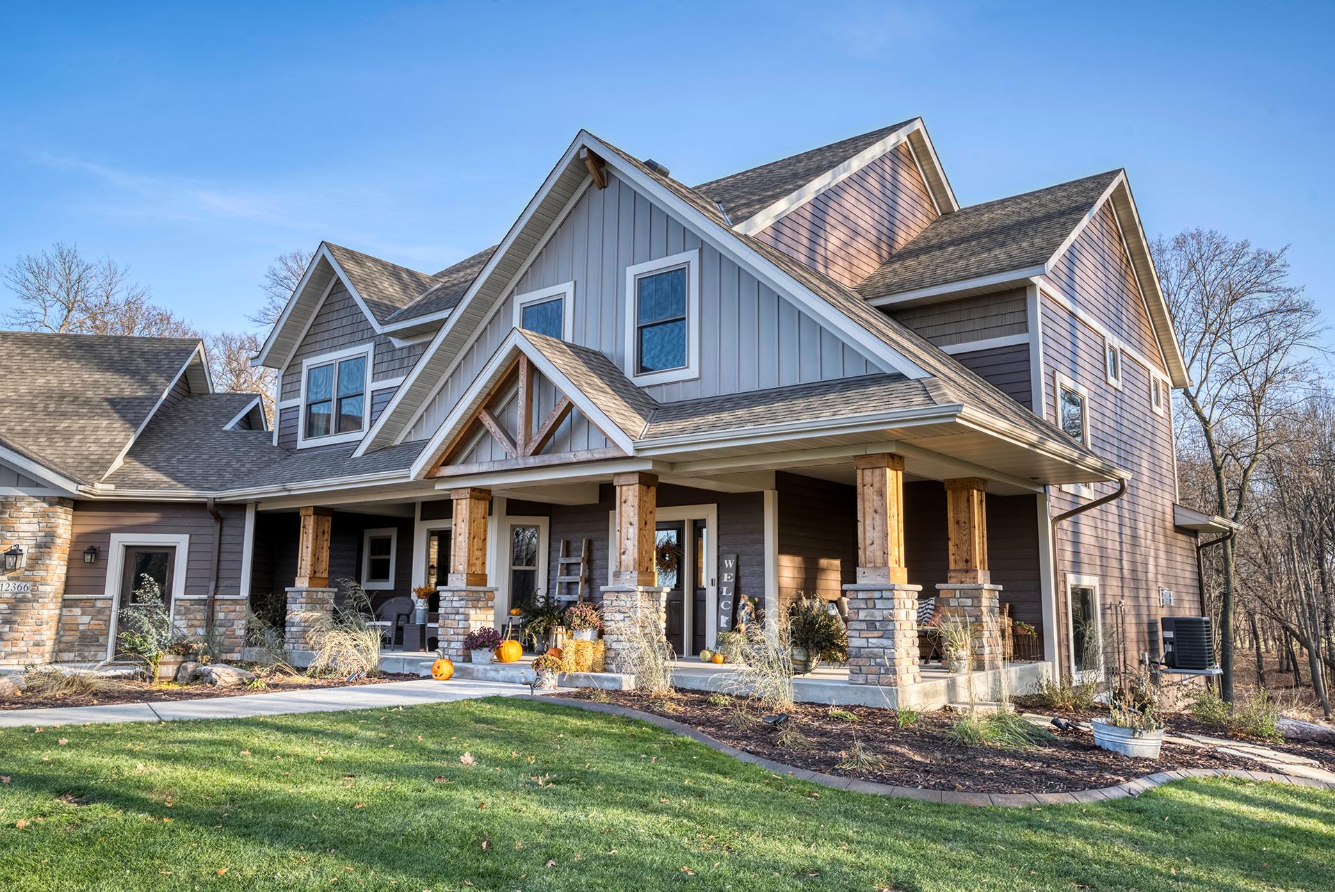 A modern farmhouse with metal board and batten siding in Driftwood Gray and Timber, blending rustic charm with refined design.