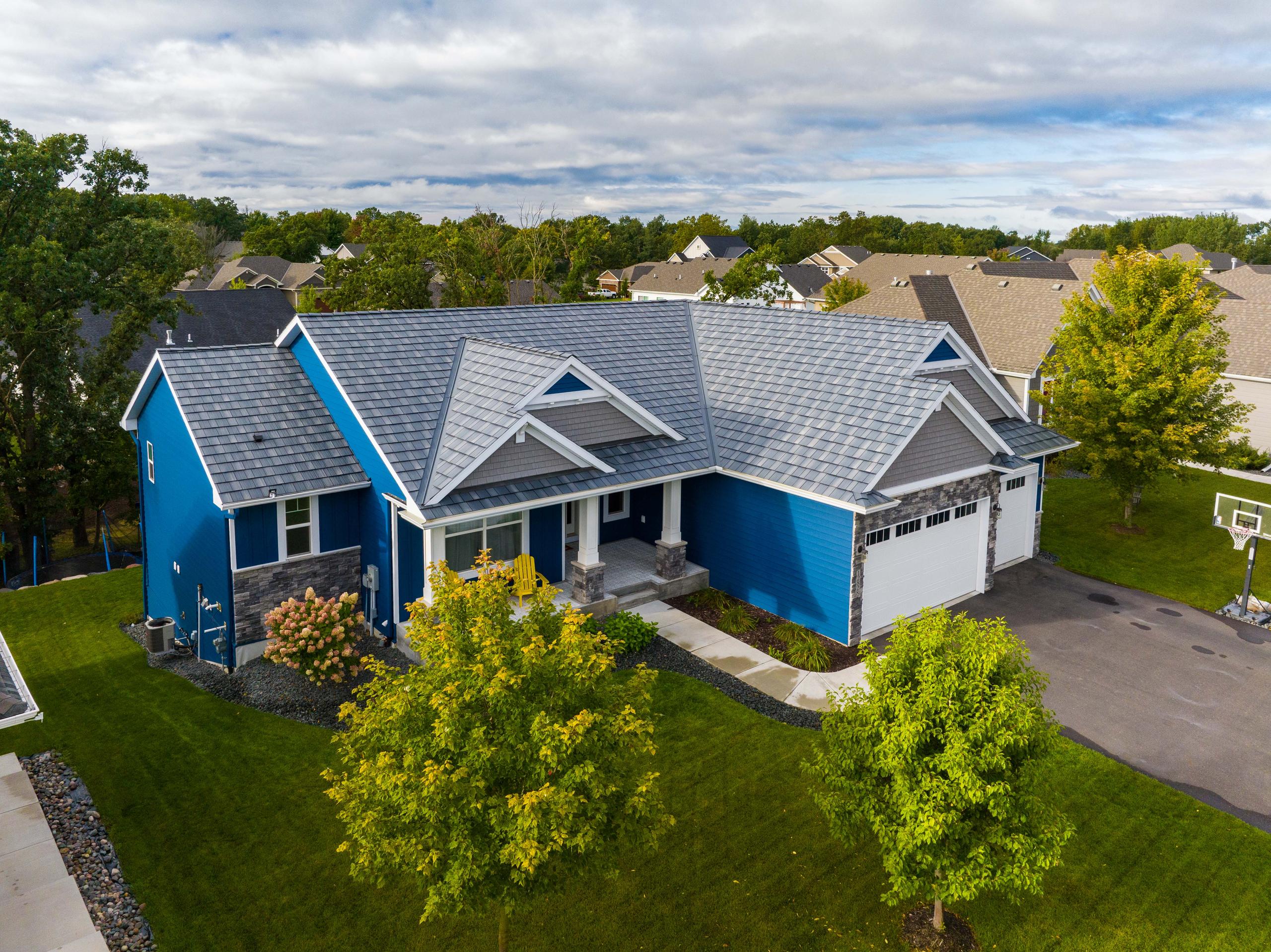 A modern home with steel shake roofing and vibrant blue siding, showcasing EDCO’s low-maintenance and durable exterior materials.