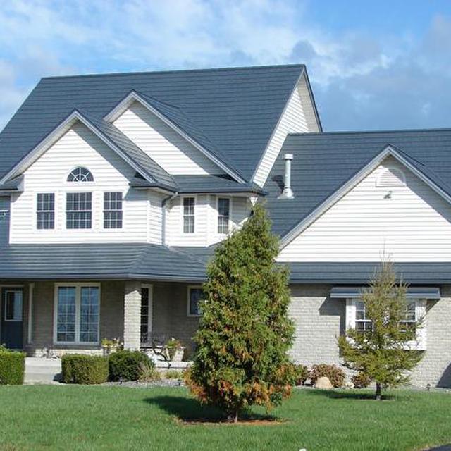 This beautiful two-story home located on an acreage showcases EDCO's slate classic blue steel roofing to give it an authentic look.